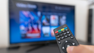 Comando de televisão apontado ao ecrã para teste a televisores.